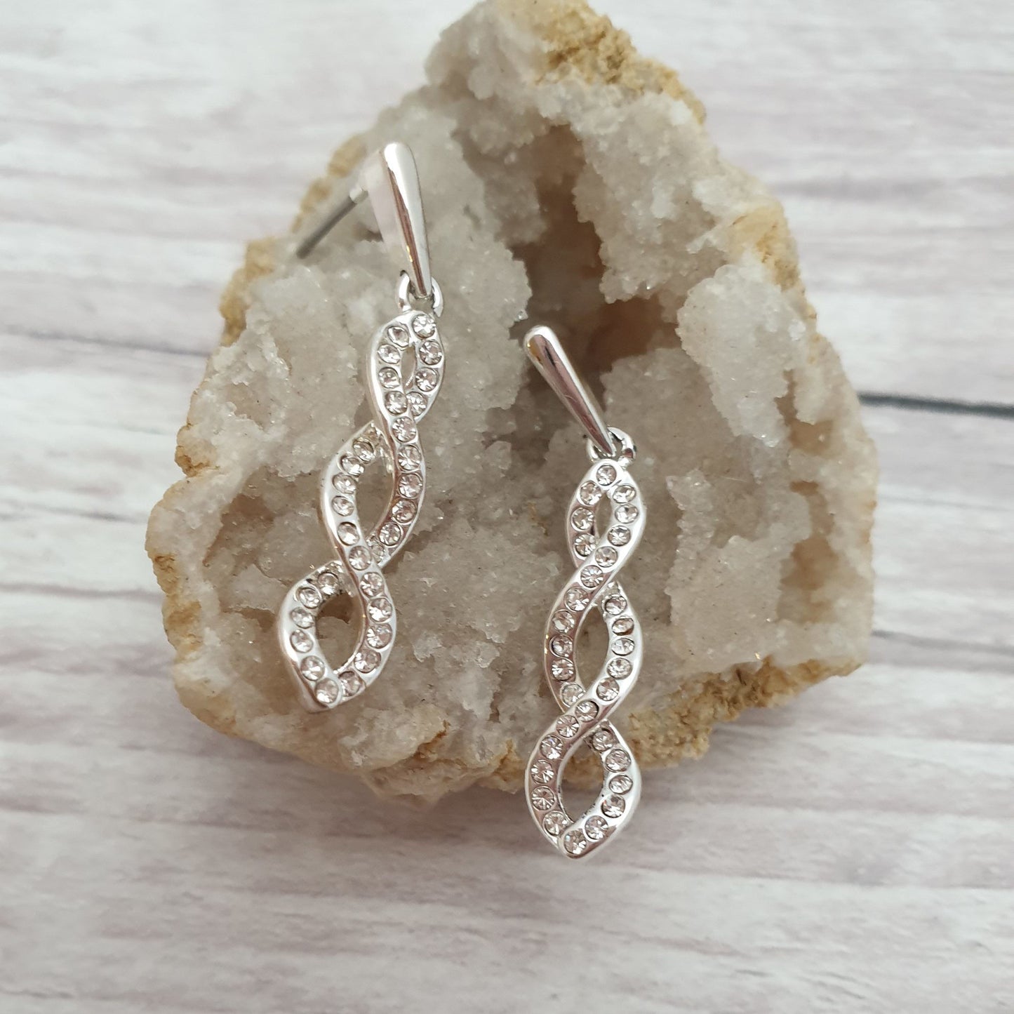 Photo of a pair of long drop earrings with a 3 loop twist set with diamante crystals