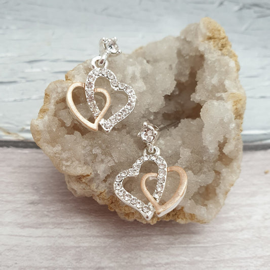 Photo of a pair of interwoven love heart earrings in a rose gold and silver diamante crystal finish