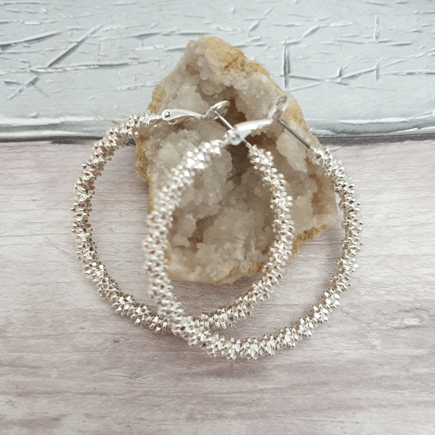 Photo of a pair of hoop earrings formed from stack of silver squares