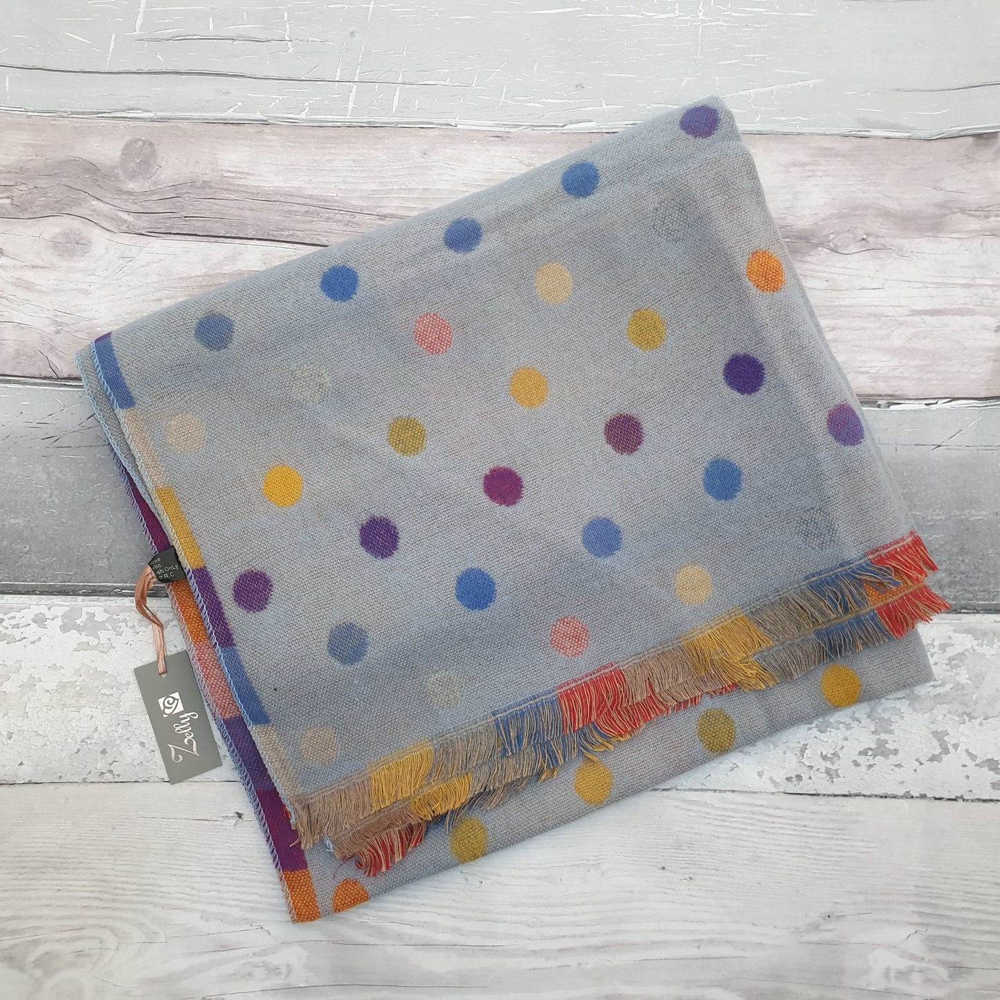 Photo of a blue scarf with rainbow coloured spots