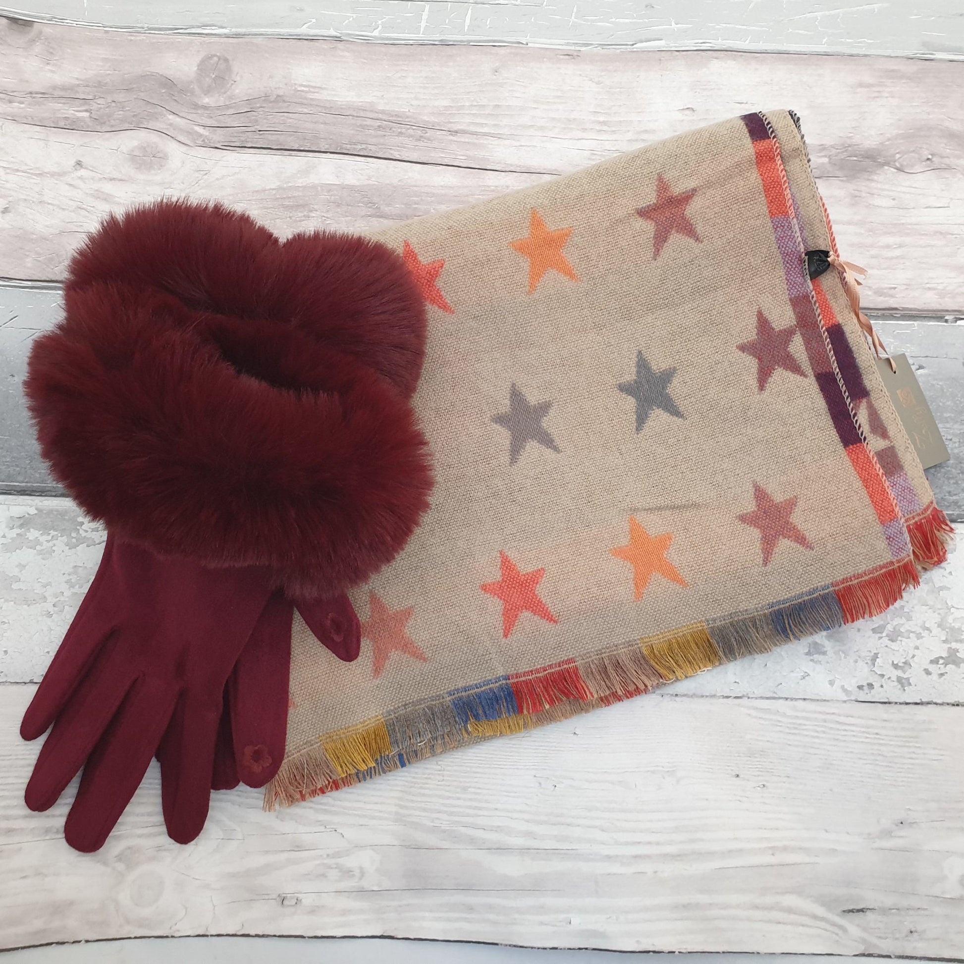 Photo of a coffee coloured scarf decorated with rainbow coloured stars