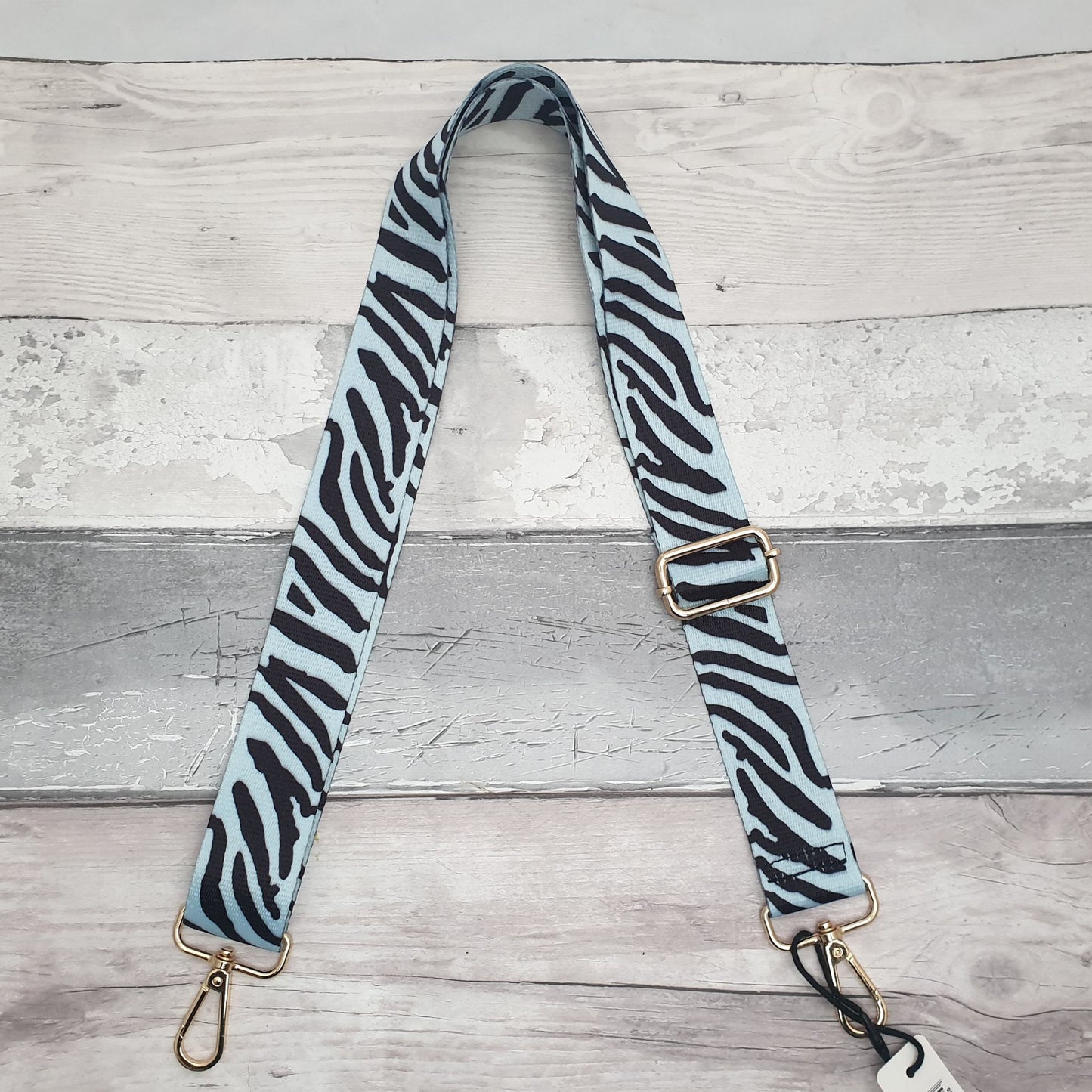 Photo of an ice blue and black zebra print bag strap