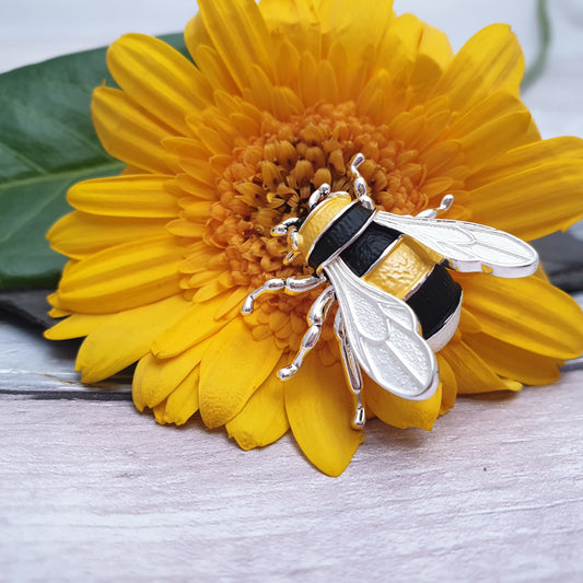 Photo of a life like Bumble Bee Brooch in vivid yellow and black stripes with silver wings and legs