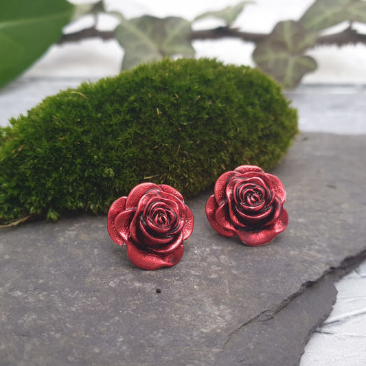 Photo of a pair of vivid red earrings in the shape of a rose.