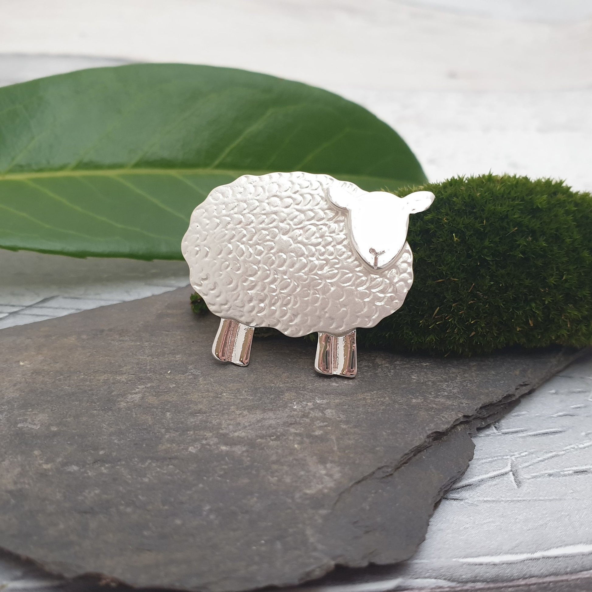 Photo of a silver tone sheep brooch with curly coat and a wooly body