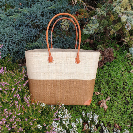 Photo of a large two tone tan and natural raffia basket with leather handles