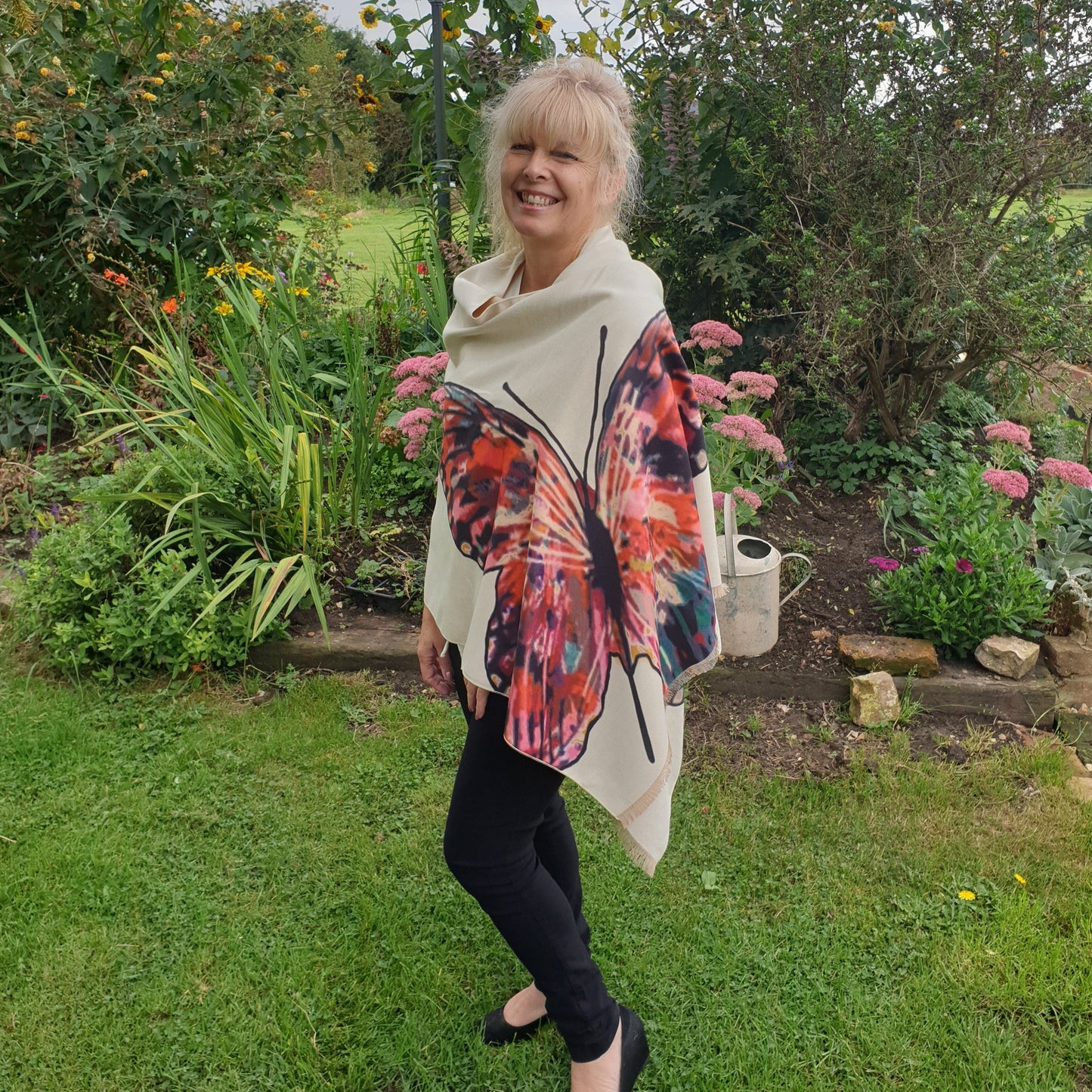 Lady wearing a cream pashmina with a brightly coloured butterfly print