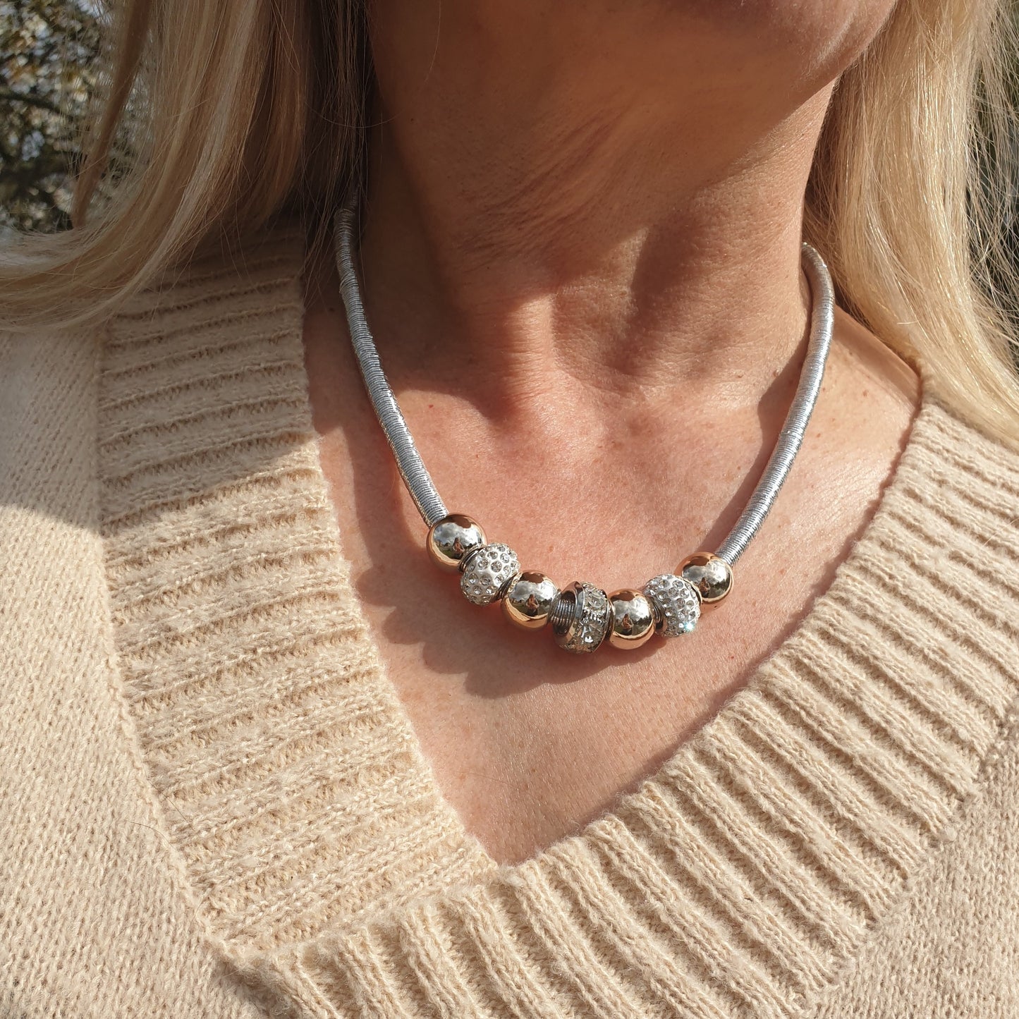 lady bearing a silver and rose gold beaded necklace