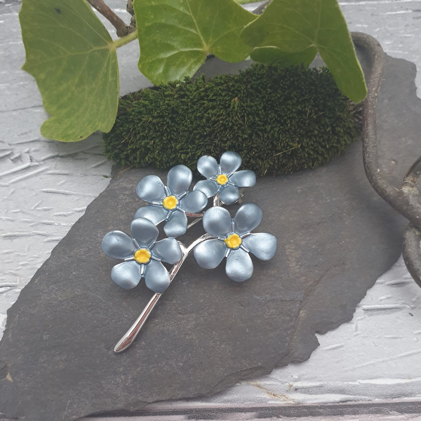 4 flower forget-me-not brooch on a silver coloured stem