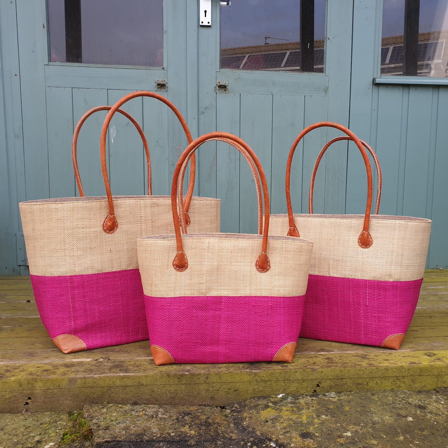 Set of 3 raffia baskets in pink and natural raffia. Small, medium and large with leather handles