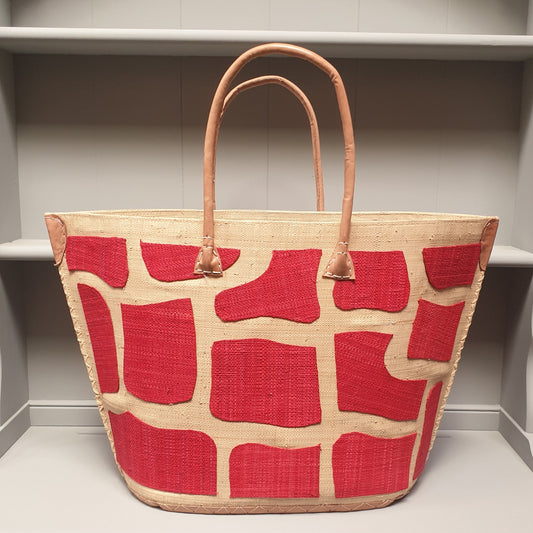 Raffia Basket with red giraffe print panels and leather handles.