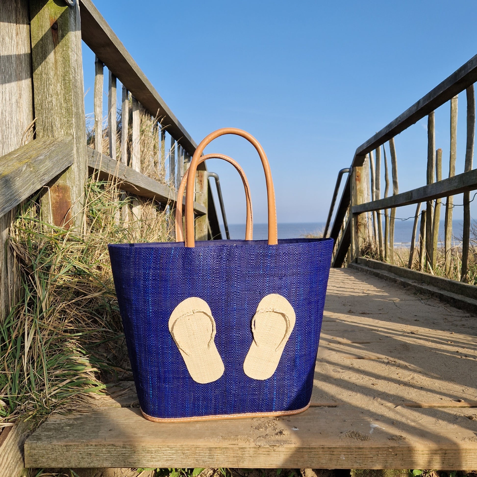 Navy Raffia Basket with a pair of Flip Flops decorating one side.