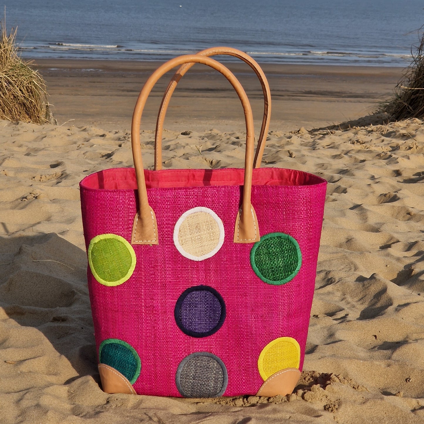 Pink raffia baskets with coloured spotty pattern.