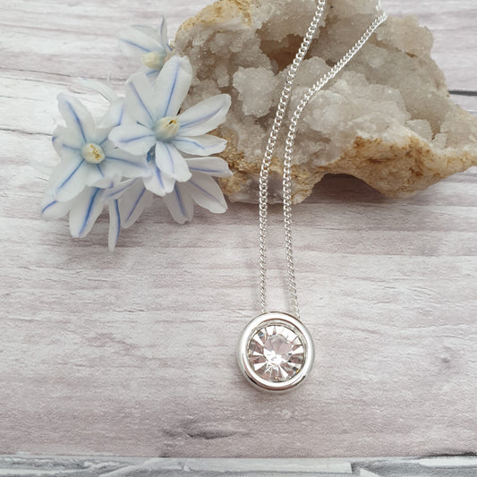 Circular CZ clear crystal pendant on a silver plated necklace