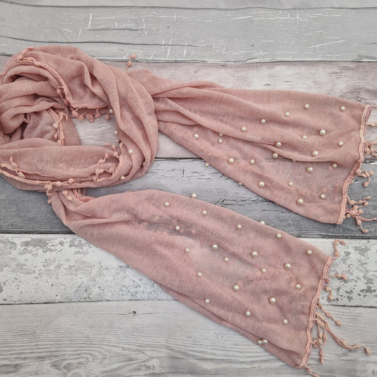 Pale pink scarf decorated with pearls and finished with matching pink tassels.