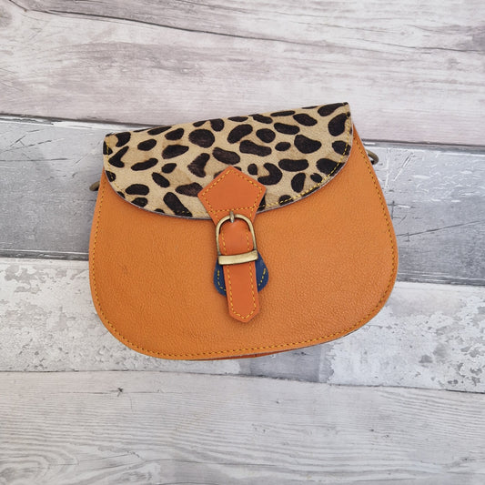 Orange leather handbag with a textured animal print panel.