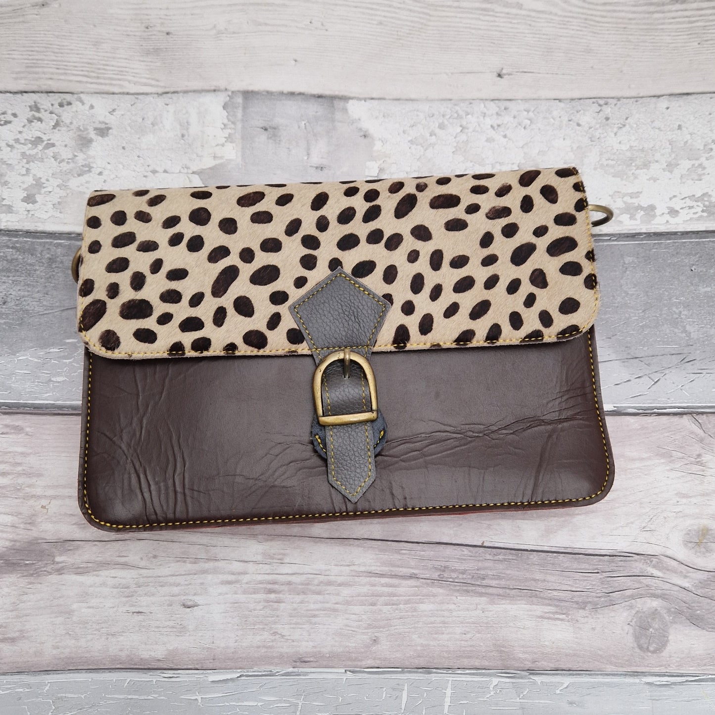 Chocolate coloured leather bag with a textured spotty print panel.