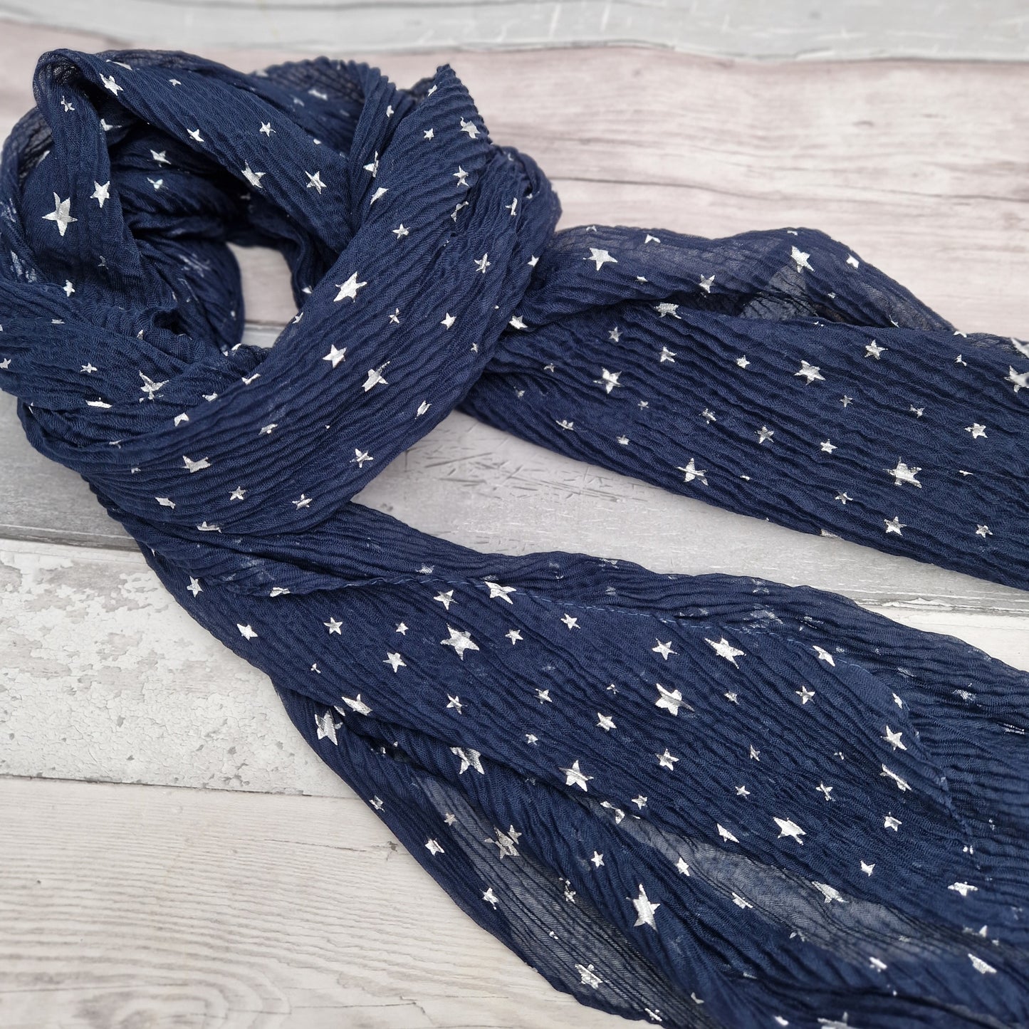 Navy crinkle finish scarf decorated with silver metallic stars.