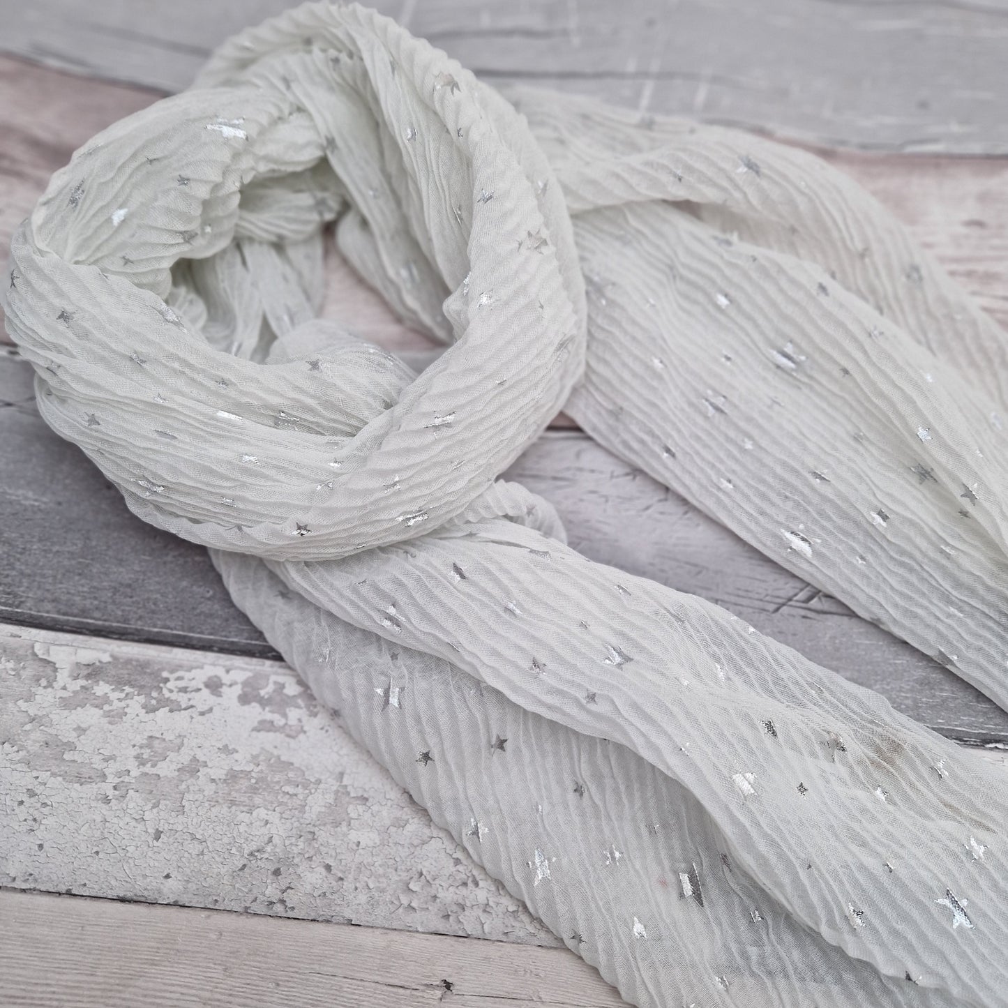 White crinkle scarf covered in metallic silver stars.