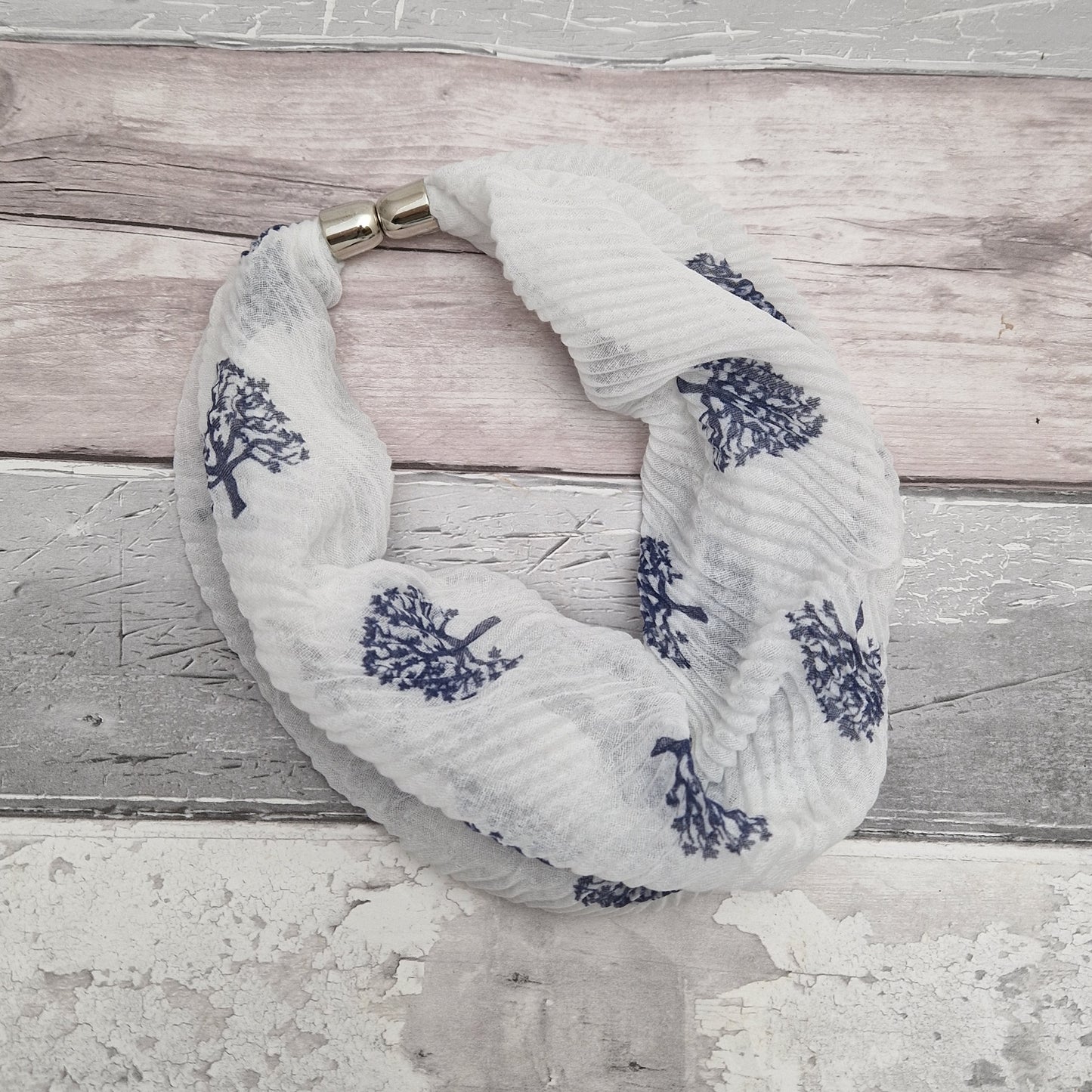 White neck scarf with a navy tree of life print.