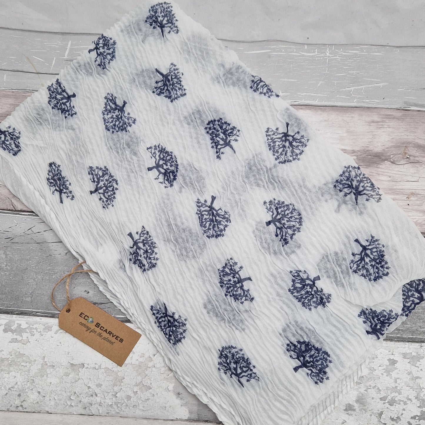 White crinkle scarf decorated with navy tree of life motifs.