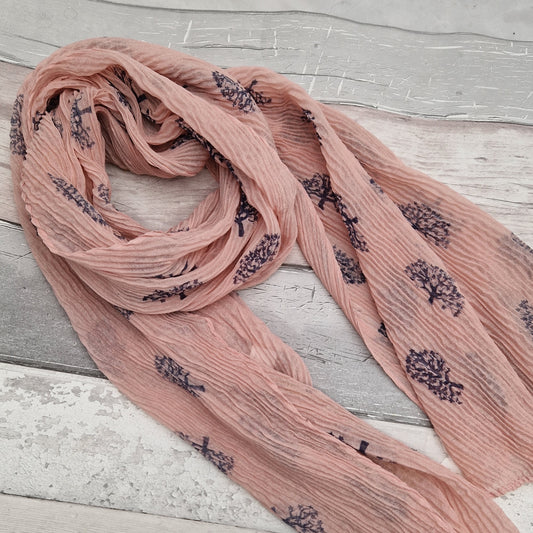 Pink crinkle scarf decorated with navy tree of life motifs.