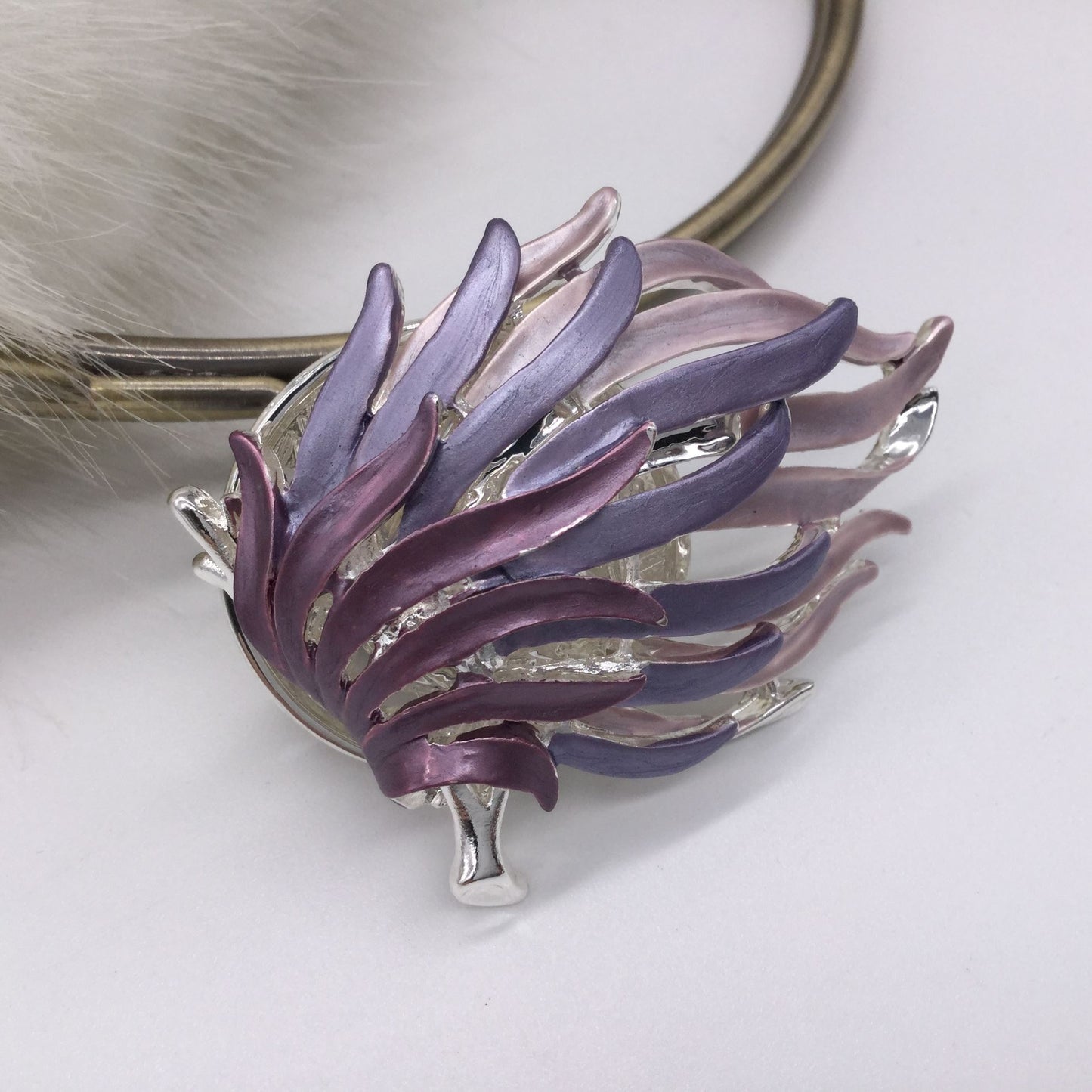 Silver torch brooch with waves of purple flames
