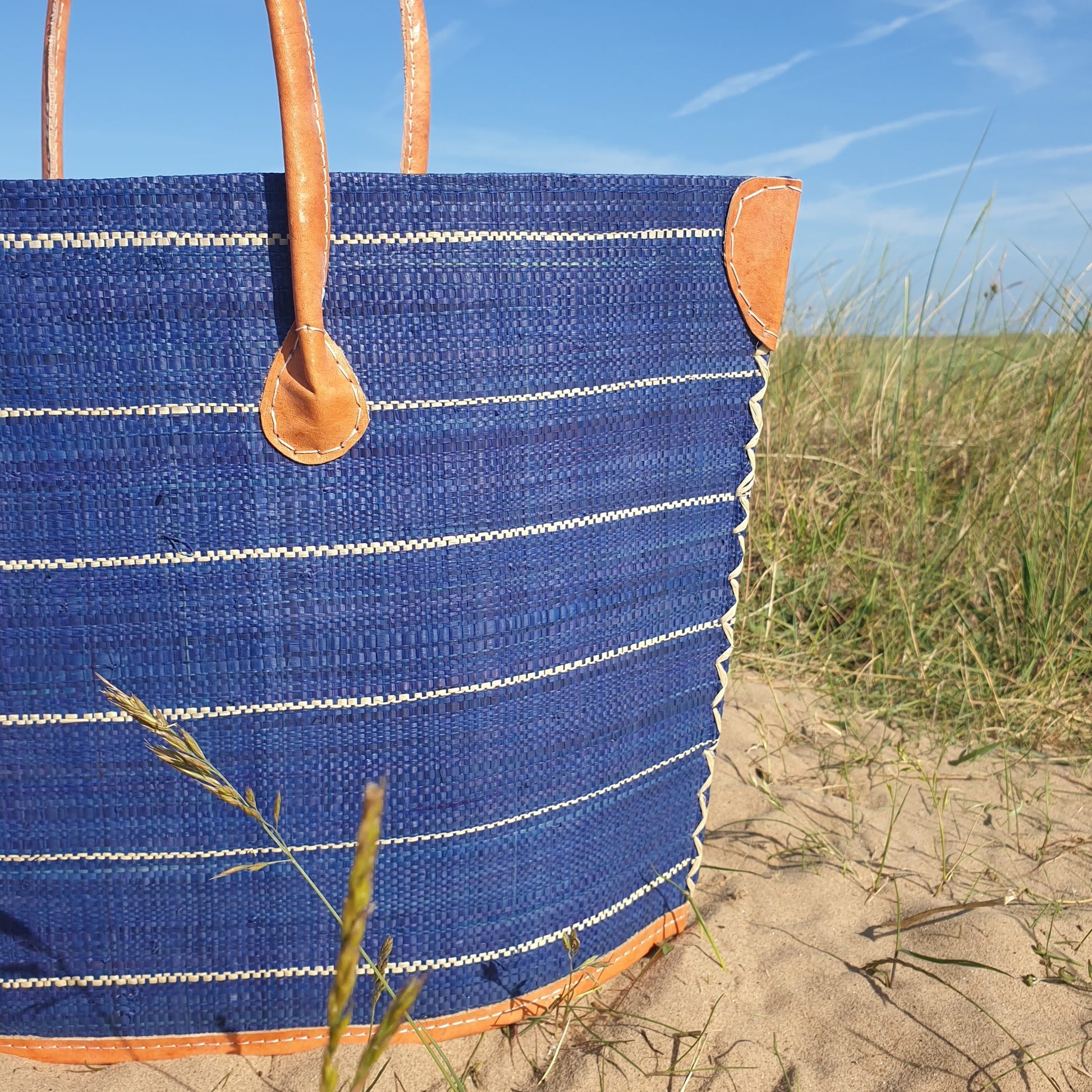 Navy Pinstriped Raffia Basket with leather handles and leather trim.