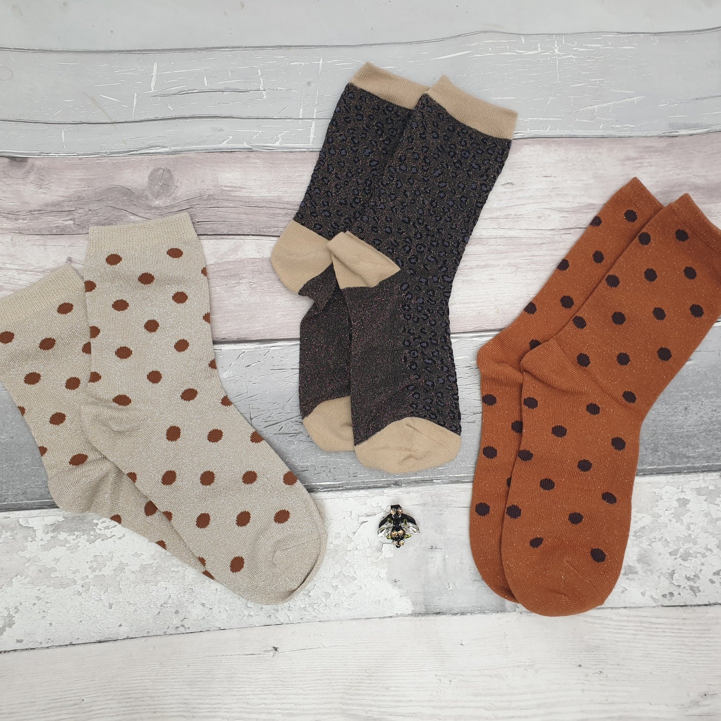 3 Pairs of Socks; cream spotty, copper spotty and silver grey leopard print, all with a sparkly finish. Set is completed with a Bee Brooch.