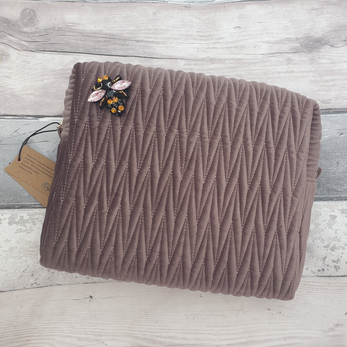 Mushroom coloured velvet quilted wash bag with a removable bee brooch.