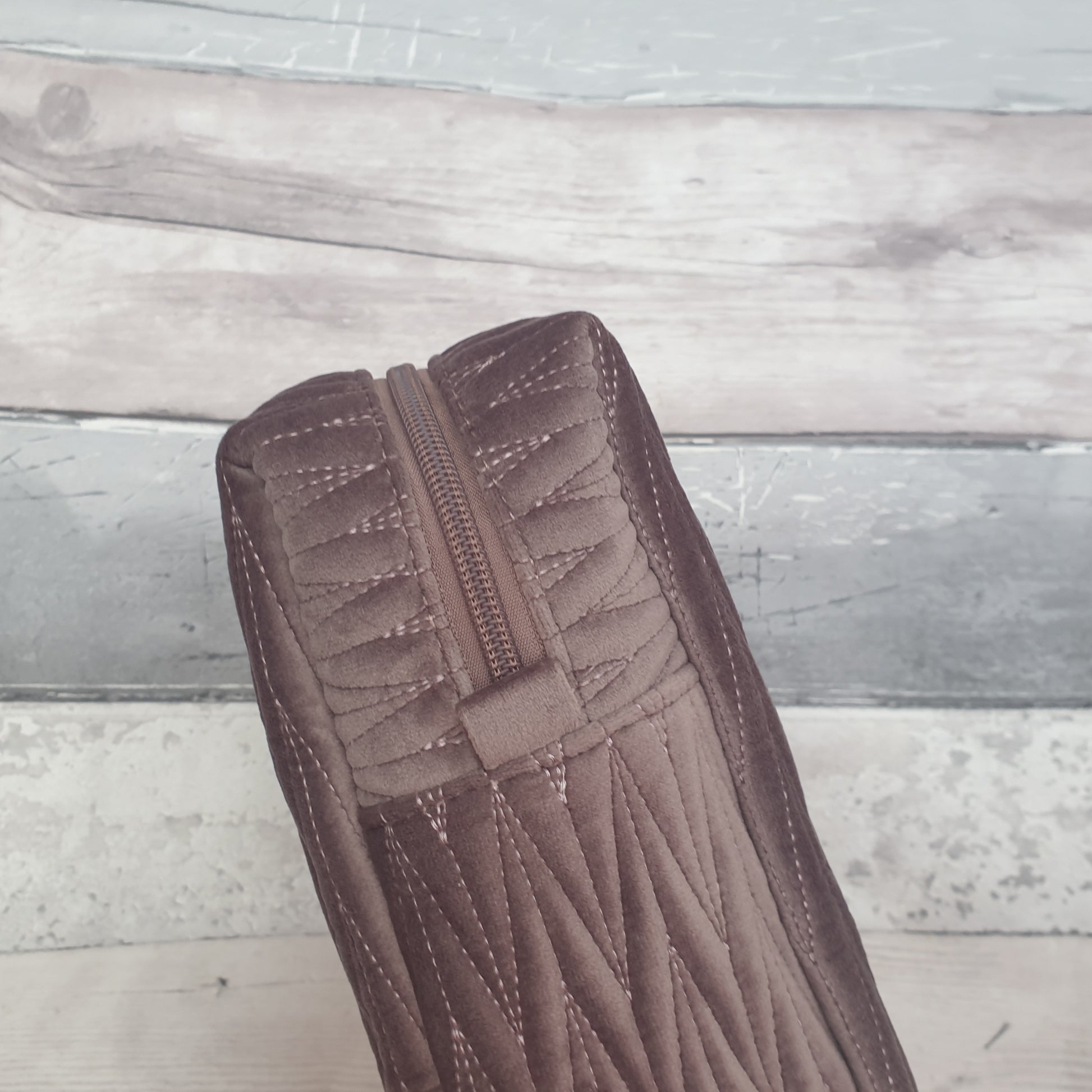 Mushroom coloured velvet quilted wash bag with a removable bee brooch.