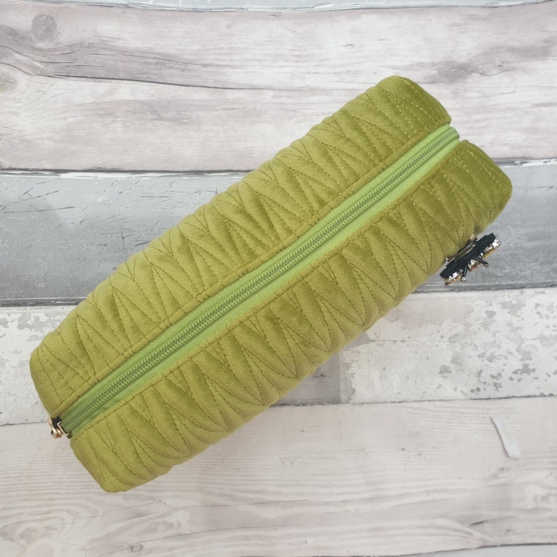 Apple green coloured velvet quilted wash bag with a detachable bee brooch.Apple green coloured velvet quilted wash bag with a detachable bee brooch.