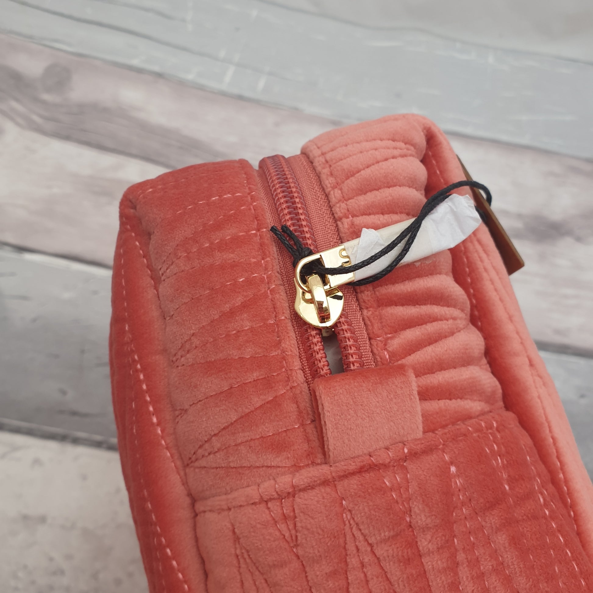 Salmon Pink coloured washbag in quilted velvet with a removable Bee Brooch in Black and Gold.