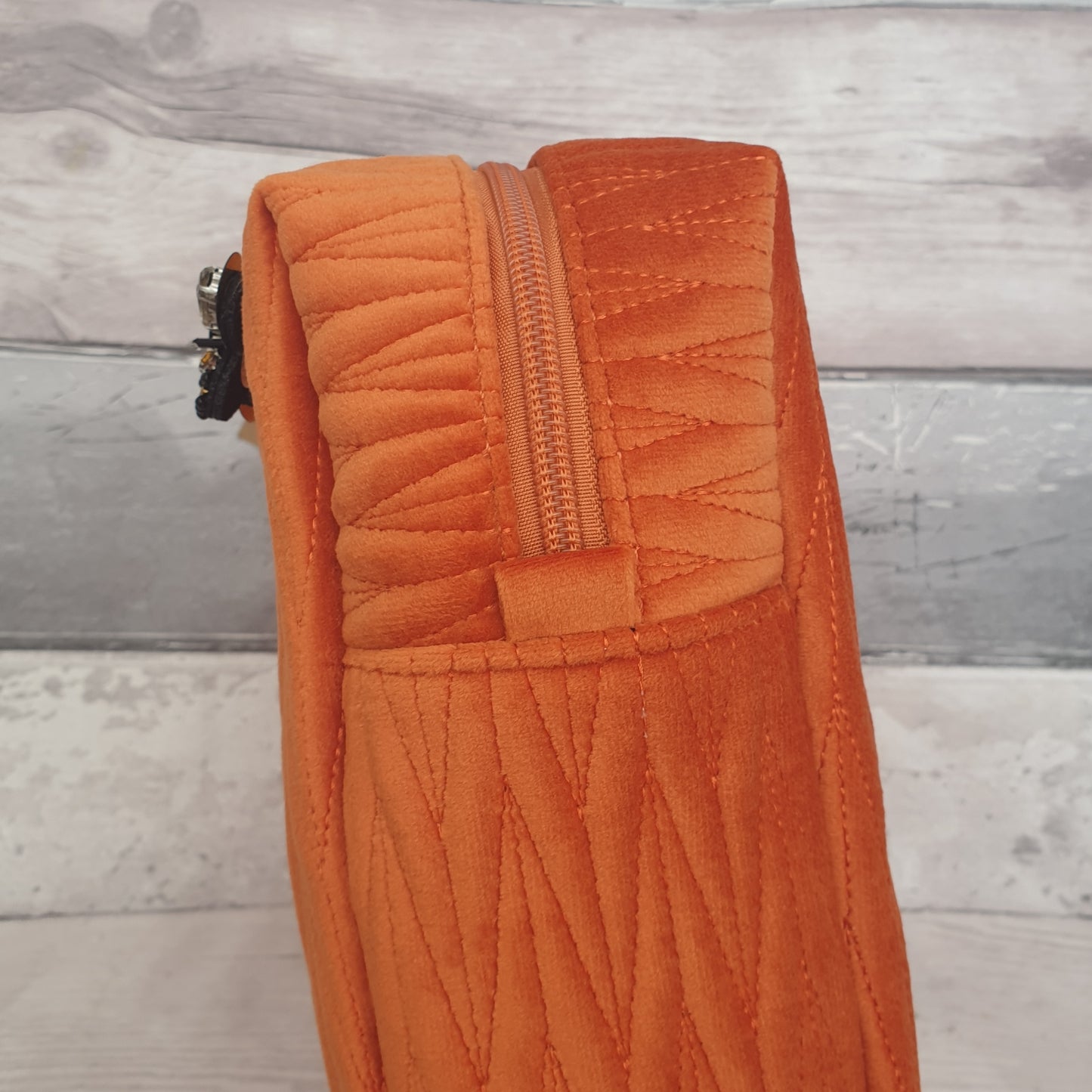 Vibrant Jaffa Orange Velvet Quilted Washbag with a detachable Black and Gold Bee Brooch.