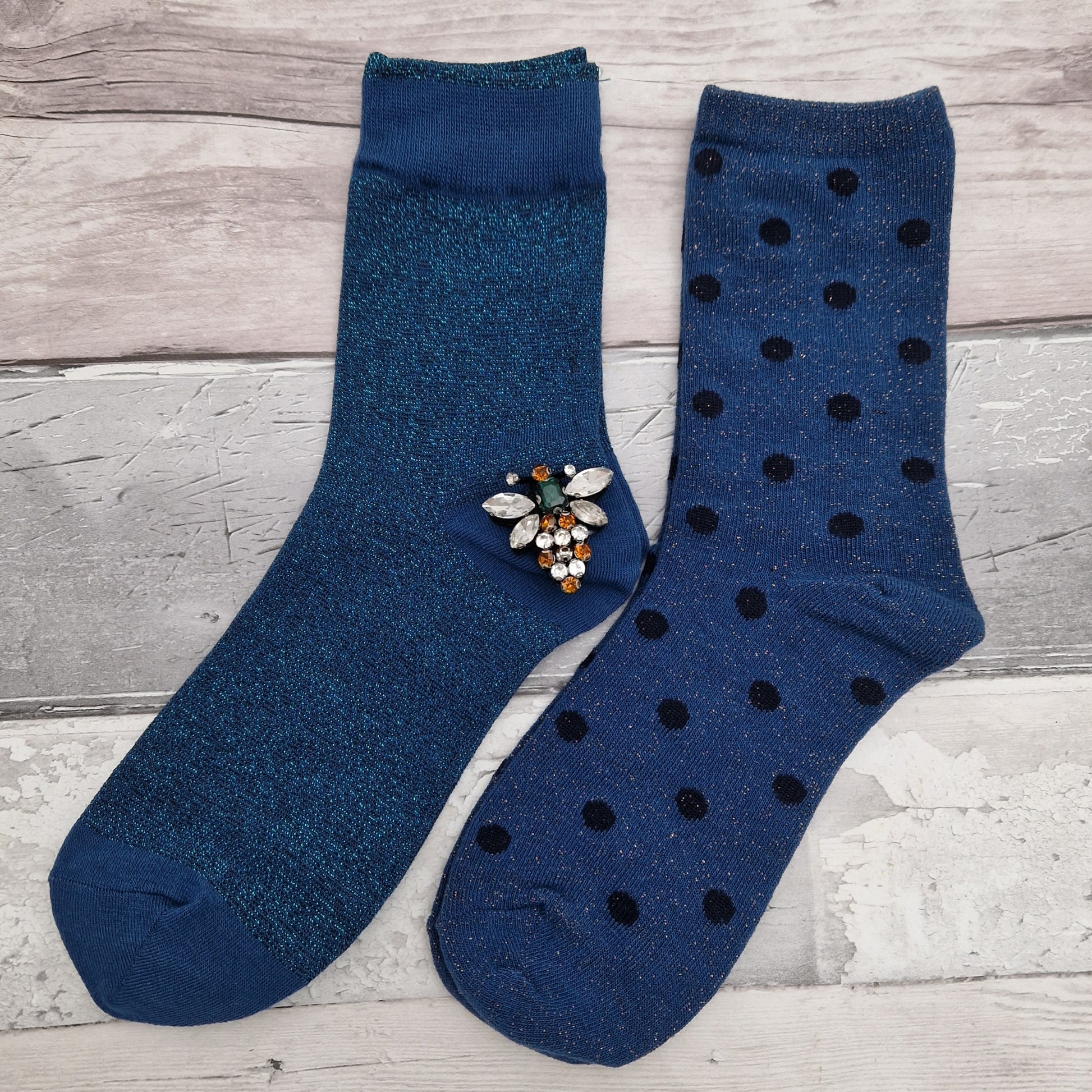 2 Pairs of blue coloured socks presented in a gift box with a sparkling Bee Brooch made of recycled glass.