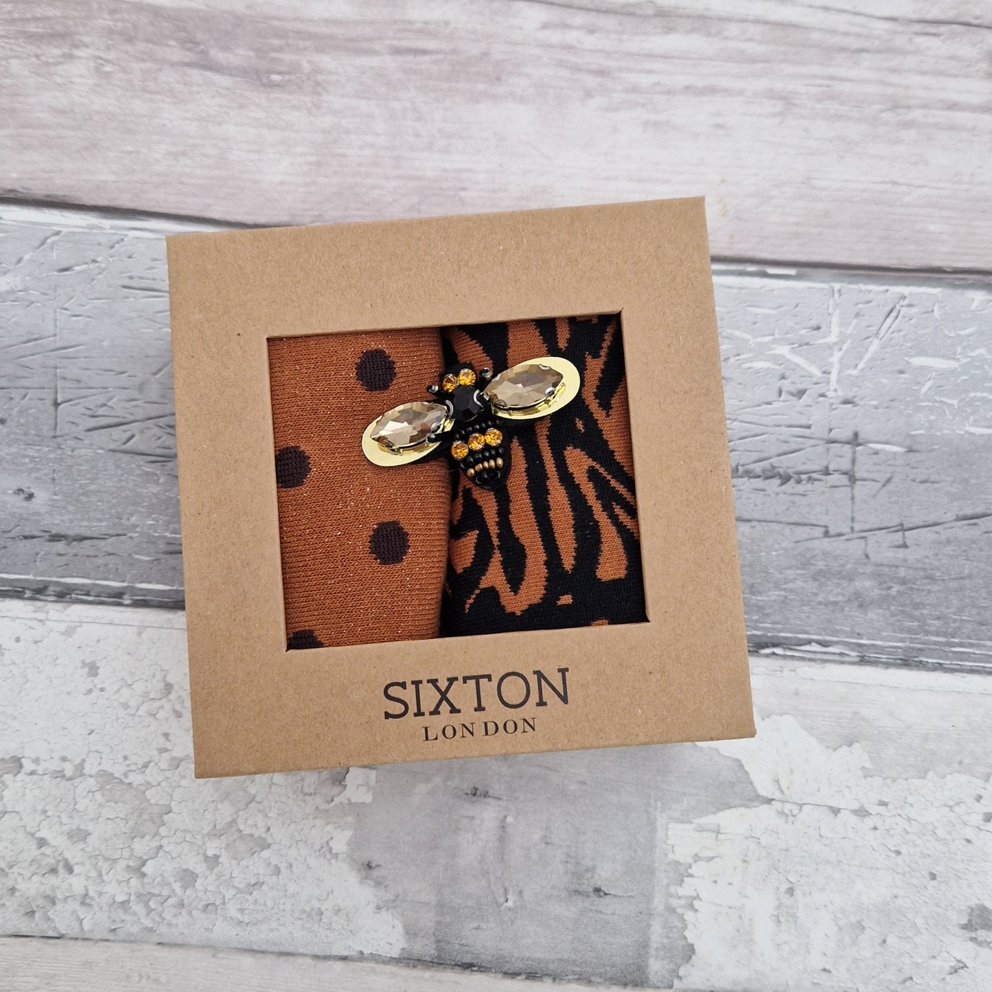 2 Pairs of rust coloured socks presented in a gift box with a sparkling Bee Brooch made of recycled glass.