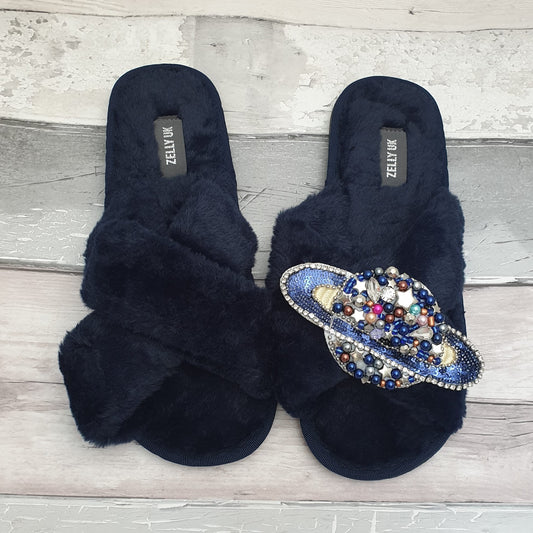 Navy fluffy slippers with a brooch on the front in the shape of Saturn, covered in sparkling sequins