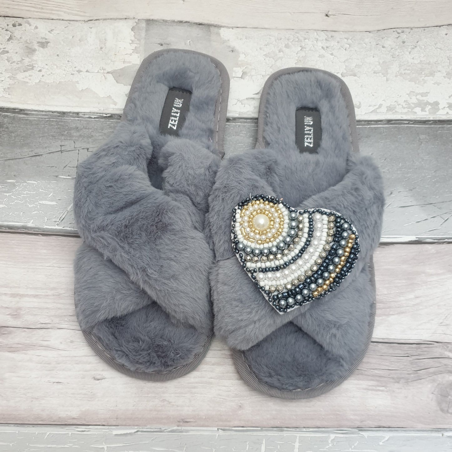 Fluffy grey slippers with a heart shaped brooch covered in sequins and beads