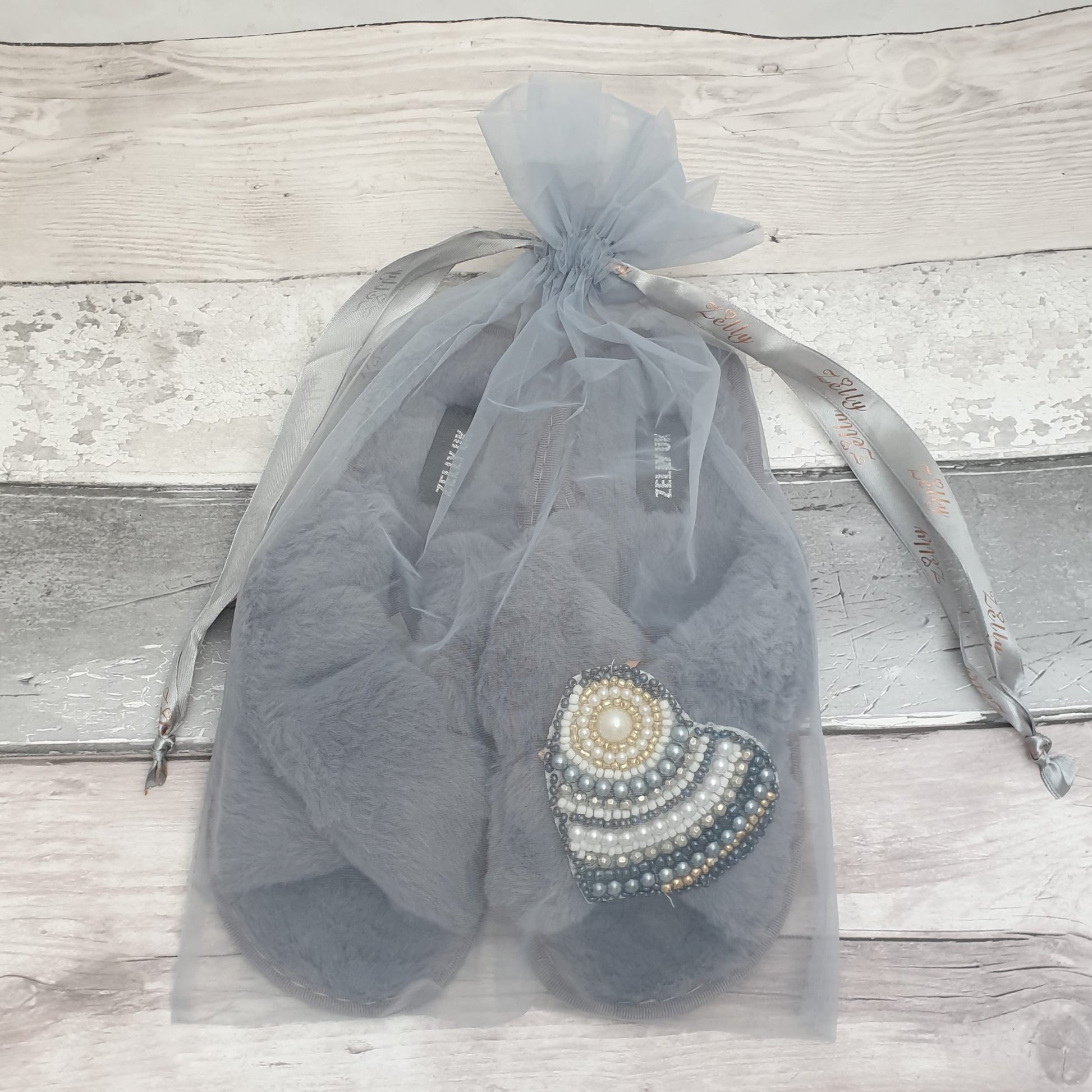 Grey fluffy slippers in an organza bag
