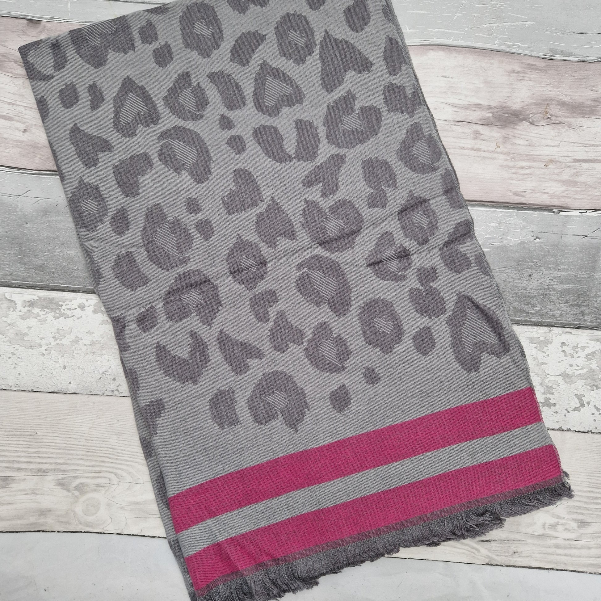 Silver grey leopard print scarf finished with a pink trim.