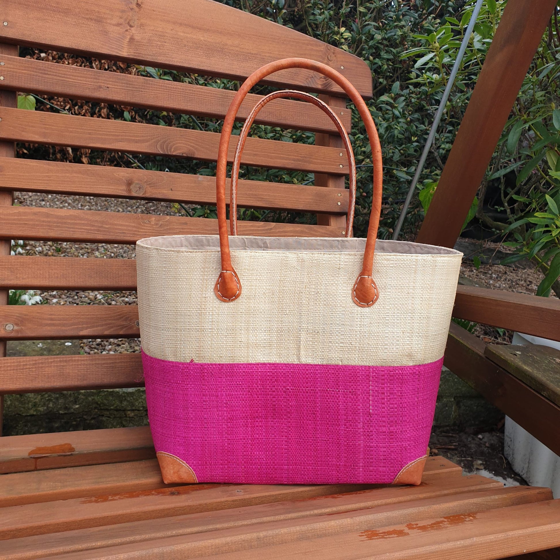 pink and natural raffia basket with leather handles